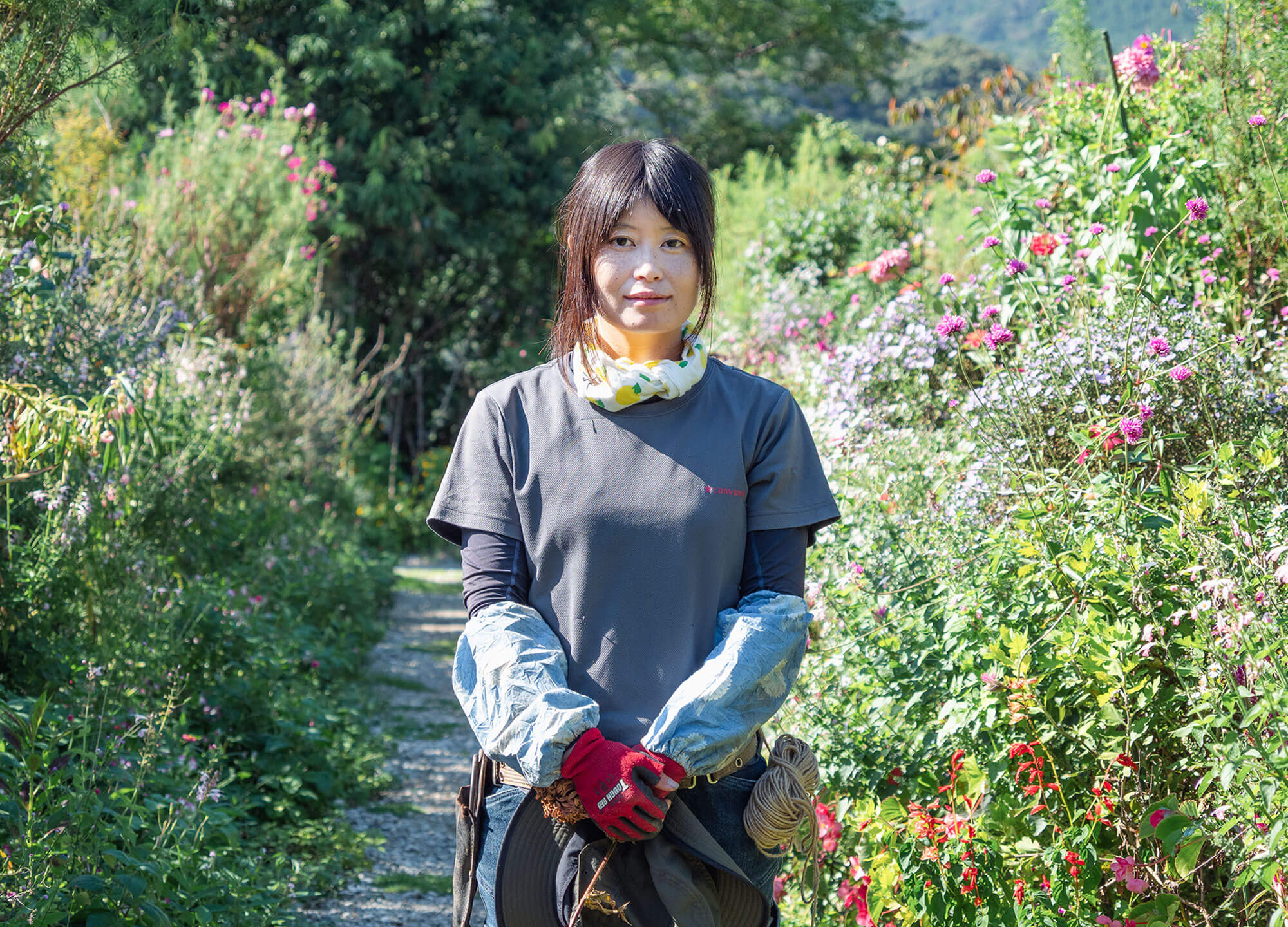 写真:花の庭で微笑む女性