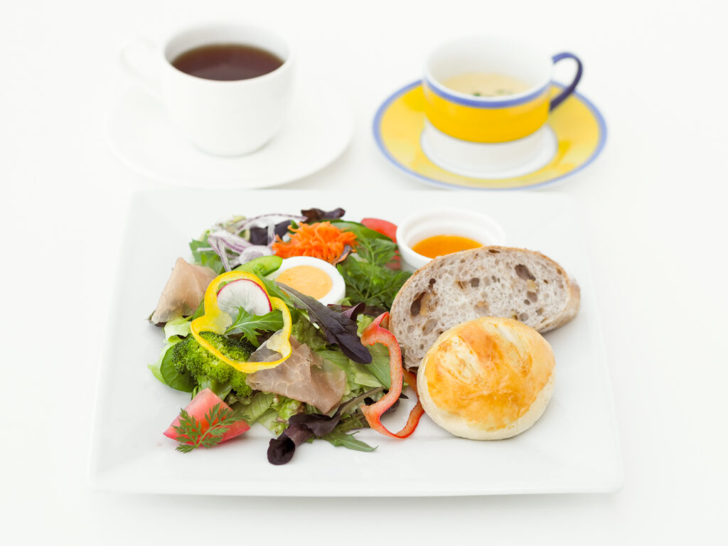 写真：色とりどりのサラダとパンがのったプレートと、スープ、ドリンク